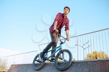 Bmx biker doing trick,teenager on training in skatepark. Extreme bicycle sport, dangerous cycle exercise, risk street riding, biking in summer park