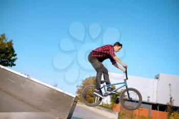 Bmx biker doing trick on stairs,teenager on training in skatepark. Extreme bicycle sport, dangerous cycle exercise, risk street riding, biking in summer park