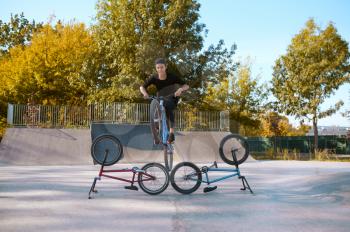 Bmx bikers lifestyle, training in skatepark. Extreme bicycle sport, dangerous cycle exercise, street riding, teens biking in summer park