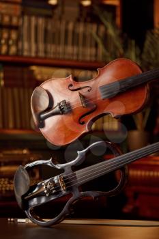 Violin in retro style and modern electric viola, nobody. Two classical string musical instruments, music art, dark background