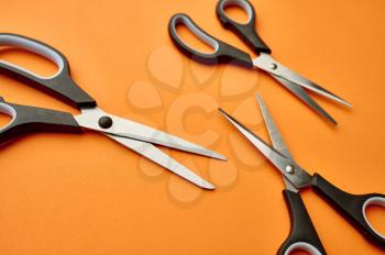 Set of scissors closeup, orange background. Office stationery supplies, school or education accessories, writing and drawing tools