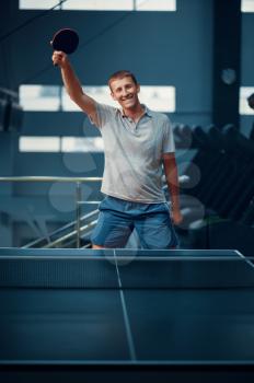 Man wins table tennis match, ping pong player. Sportsman playing table-tennis indoors, sport game with racket, active healthy lifestyle