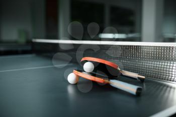 Ping pong rackets and ball at the net closeup, nobody, table tennis concept. Table-tennis indoors, sport game motivation, active healthy lifestyle, pingpong