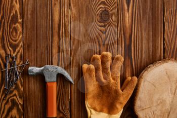 Screw nails, hammer and glove on wooden background, nobody. Professional instrument, carpenter equipment, fasteners, fastening and screwing tools
