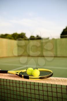 Tennis racket and balls on the net, nobody, outdoor court. Active healthy lifestyle, sport game concept
