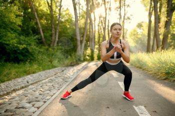 Morning training in park, woman prepares for running. Female runner goes in for sports at sunny day, healthy lifestyle, jogger on outdoors workout