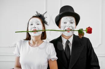 Two mime artists, love couple with rose in teeth. Pantomime theater, parody comedian, positive emotion, humour performance, funny face mimic and grimace
