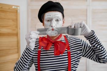 Mime artist with duct tape, parody comedy. Pantomime theater, comedian, positive emotion, humour performance, funny face mimic and grimace