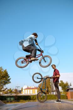 Bmx biker on ramp, jump in action, training in skatepark. Extreme bicycle sport, dangerous cycle exercise, street riding, teens biking in the park