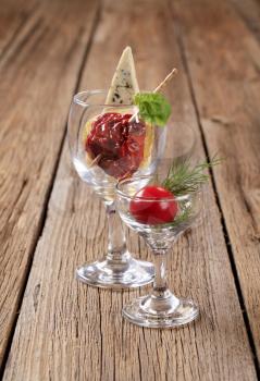 Dried tomato and slice of blue cheese in wine glass