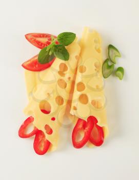 Thin slices of Swiss cheese garnished with vegetables