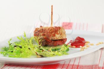 Meatball appetizer garnished with fresh endive and pine nuts