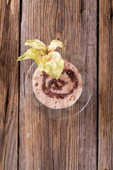 Glass of chocolate smoothie garnished with fresh fruit
