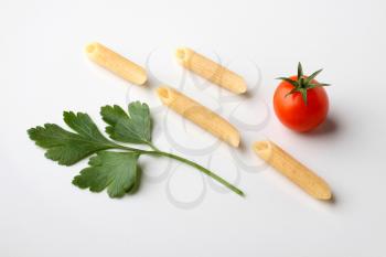 Whole wheat pasta tubes, fresh cilantro leaf and tomato 