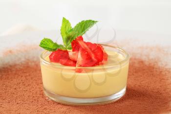 Small dish of custard topped with strawberry