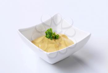 Creamy mustard in a small square bowl 