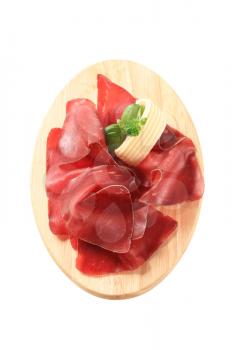 Thin slices of dried meat on a cutting board