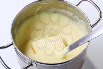 Mashed potato and butter in a pot