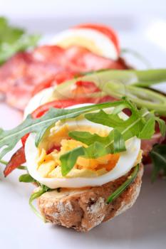 Brown bread roll with roasted bacon and egg