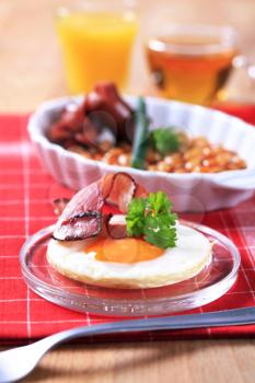 Fried egg with bacon and baked beans with grilled sausages