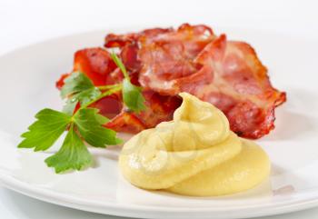 Pan fried bacon slices and mustard sauce
