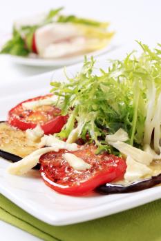 Grilled aubergine and tomato with salad greens and cheese