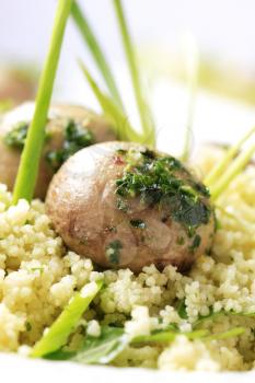 Couscous and button mushrooms garnished with spring onion