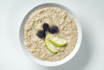 Bowl of porridge topped with blackberries and apple

