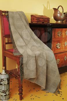 Ornamental antique furniture
 and a woven throw