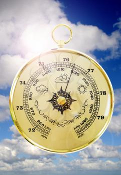 Barometer with cloudy sky in the background 
