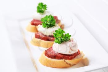 Canapes with spicy salami and savory spread