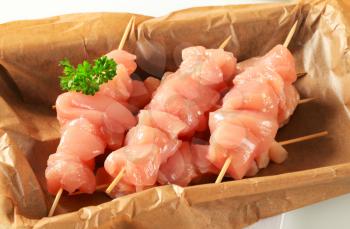 Diced chicken meat on wooden skewers