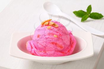 Scoop of pink ice cream on a dessert plate