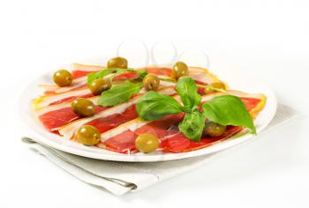 Thin slices of prosciutto crudo and marinated green olives