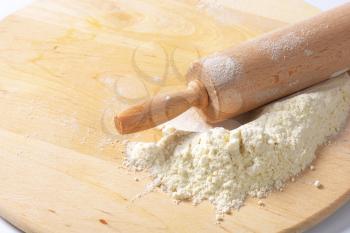 Flour and rolling pin on a wooden board