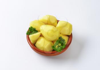 Raw peeled potatoes in ceramic dish