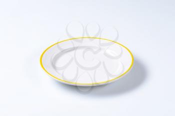 Rimmed dinner plate with yellow colored edge