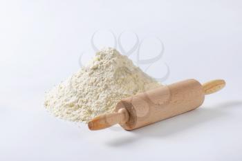 Wooden roller type rolling pin and pile of finely ground flour