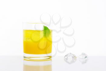 glass of fresh orange juice with ice on white background