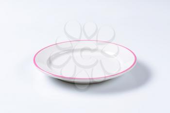 Rimmed dinner plate with pink colored edge