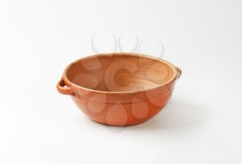 Empty round red clay bowl with two small handles