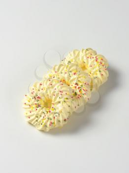 Wreath-shaped meringue cookies topped with sprinkles
