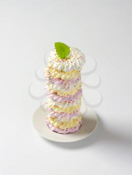 Stack of wreath-shaped meringue cookies topped with sprinkles
