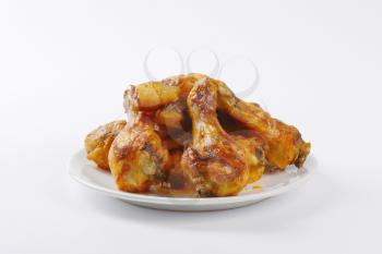 freshly roasted chicken legs on white plate
