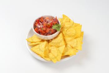 bowl of salsa fresca and tortilla chips on white plate