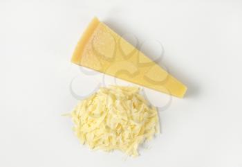 grated parmesan cheese and wedge on white background