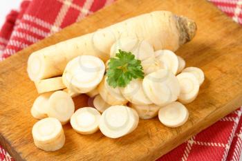 close up of sliced parsley root on wooden cutting board