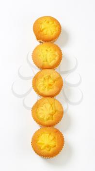 Row of lemon cupcakes on white background