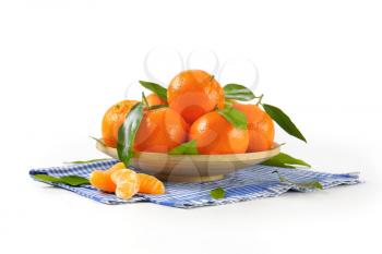 plate of ripe tangerines on checkered dishtowel