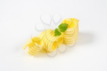 Curls of fresh butter on white background